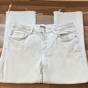 Zara brand light-wash denim jeans featuring a straight-leg cut and a raw, frayed